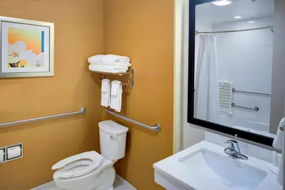 a bathroom with a toilet and a sink and a mirror at Fairfield Inn & Suites by Marriott Hollister in Hollister