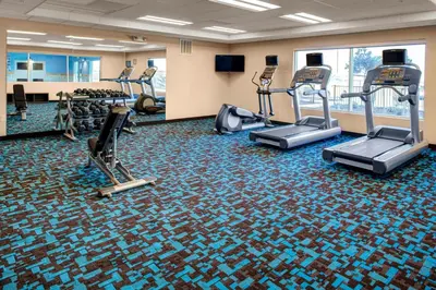 a gym with treadmills and ellipticals on the floor at Fairfield Inn & Suites by Marriott Hollister in Hollister
