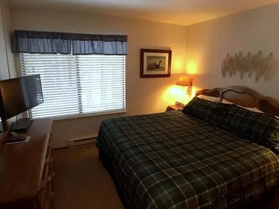 a bedroom with a bed and a television and a window at 102 Standard Condo in Mammoth Lakes