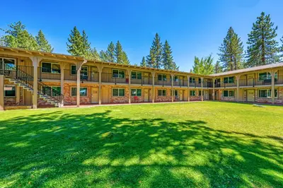 an exterior view of a large building with a large yard at The Lodge at Lake Tahoe in South Lake Tahoe
