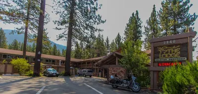 a hotel with a motorcycle parked in a parking lot at The Lodge at Lake Tahoe in South Lake Tahoe