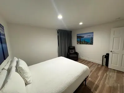 a bedroom with a white bed and a chair at Firelite Lodge in Tahoe Vista
