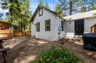 a white house with a picnic table in front of it at Firelite Lodge in Tahoe Vista