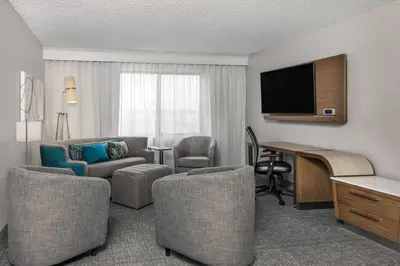 a hotel room with a desk and a living room at Courtyard by Marriott Reno in Reno