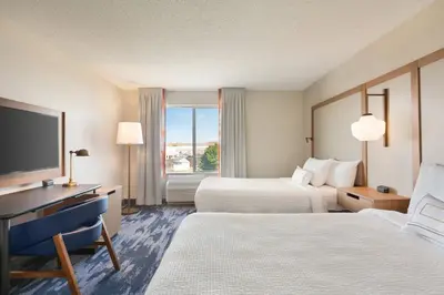 a hotel room with two beds and a flat screen tv at Fairfield Inn & Suites by Marriott Reno Sparks in Sparks