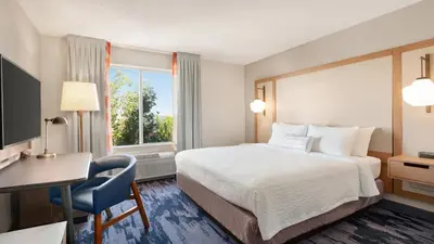 a hotel room with a bed and a desk and a window at Fairfield Inn & Suites by Marriott Reno Sparks in Sparks