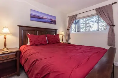a bedroom with a red bed and a window at Mammoth View Villas # 34 in Mammoth Lakes