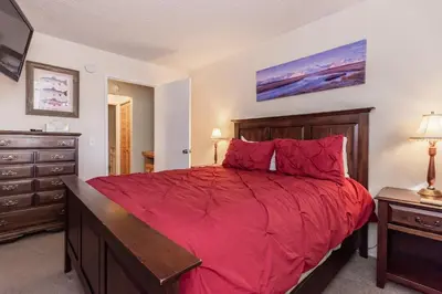 a bedroom with a large red bed and a dresser at Mammoth View Villas # 34 in Mammoth Lakes
