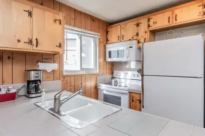 a kitchen with wooden cabinets and a white refrigerator at Mammoth View Villas # 34 in Mammoth Lakes