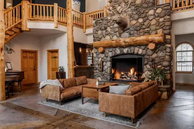 a living room with couches and a stone fireplace at Black Bear Lodge in South Lake Tahoe
