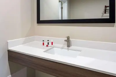 a white sink in a bathroom with a mirror at Ramada by Wyndham Modesto Yosemite Area in Modesto