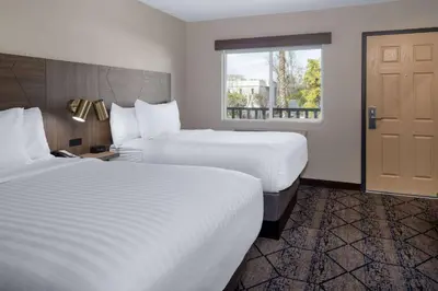 a hotel room with two beds and a window at Ramada by Wyndham Modesto Yosemite Area in Modesto