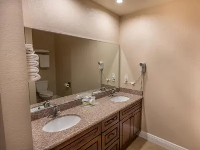 a bathroom with two sinks and a large mirror at Edge Water Inn in Reedley