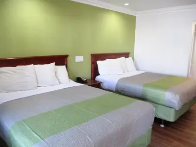 two beds in a room with green walls at Motel 6-Fresno, CA in Fresno