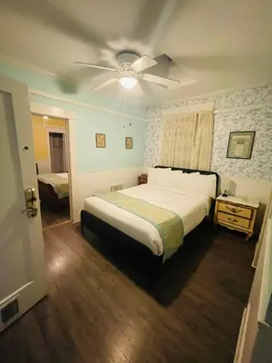 a bedroom with a large bed and a ceiling fan at Americas Best Value Inn Royal Carriage in Jamestown