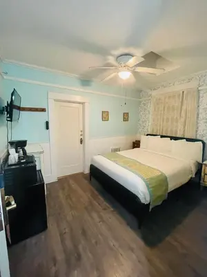 a bedroom with a bed and a ceiling fan at Americas Best Value Inn Royal Carriage in Jamestown