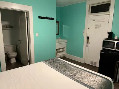 a blue room with a bed and a bathroom at Americas Best Value Inn Royal Carriage in Jamestown