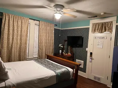 a bedroom with a bed and a ceiling fan at Americas Best Value Inn Royal Carriage in Jamestown