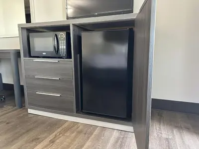 a microwave and a refrigerator in a cabinet at Summerfield Inn Fresno Yosemite in Fresno