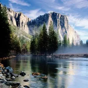 a painting of a mountain and a river with trees at Summerfield Inn Fresno Yosemite in Fresno