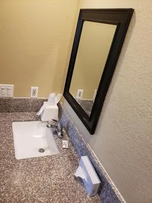 a bathroom with a sink and a mirror at University Inn Fresno in Fresno