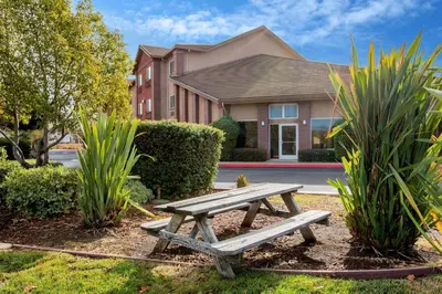 a wooden picnic table in front of a house at La Quinta Inn by Wyndham Livermore in Livermore
