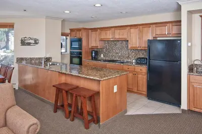 a kitchen with a black refrigerator and wooden cabinets at Holiday Inn Club Vacations - Tahoe Ridge Resort in Stateline
