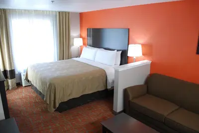 a hotel room with a bed and a couch at Quality Inn & Suites Fresno Northwest in Fresno