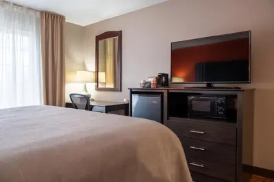 a hotel room with a bed and a flat screen tv at Quality Inn & Suites Fresno Northwest in Fresno