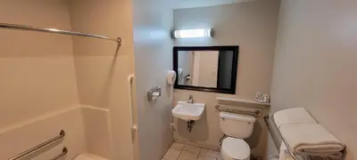 a bathroom with a toilet and a sink and a mirror at Quality Inn & Suites Fresno Northwest in Fresno