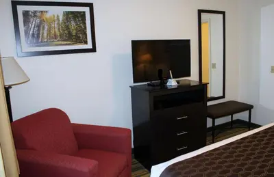 a hotel room with a tv and a chair and a televisionictericter at Best Western Visalia Hotel in Visalia