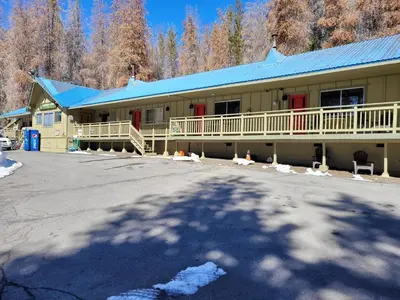 a large building with a blue roof and a parking lot at The Tamarack Lodge in Lakeshore