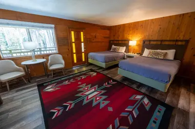a bedroom with two beds and a red rug at The Tamarack Lodge in Lakeshore