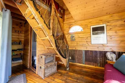 a bedroom with a loft bed in a log cabin at Hawk's Rest in Oakhurst