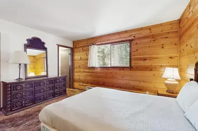 a bedroom with wooden walls and a bed and a window at Tahoma Getaway in Tahoma