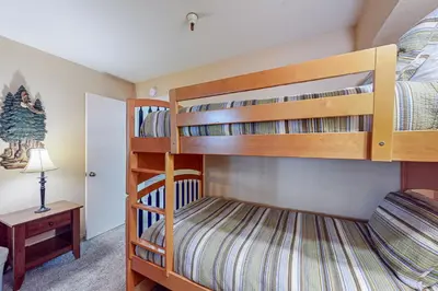 two bunk beds in a room with a lamp at The Bridges 102 in Mammoth Lakes