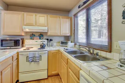 a kitchen with wooden cabinets and a sink at Wildflower 55 in Mammoth Lakes