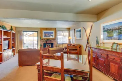 a living room with a table and a fireplace at Wildflower 55 in Mammoth Lakes