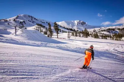 a man is skiing down a snow covered slope at La Vista Blanc 39 in Mammoth Lakes