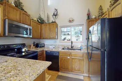 a kitchen with wooden cabinets and a stainless steel refrigerator at Woodlands 34 in Mammoth Lakes