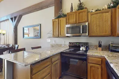 a kitchen with wooden cabinets and a stove top oven at Woodlands 34 in Mammoth Lakes