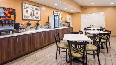 a restaurant with tables and chairs and a counter at Best Western Golden Key in Auburn