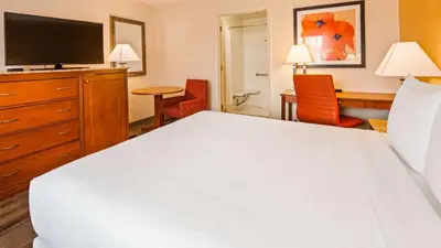 a hotel room with a bed and a television at Best Western Golden Key in Auburn