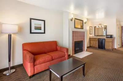 a living room with a couch and a fireplace at Best Western Luxury Inn in Tracy