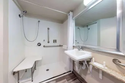 a white bathroom with a sink and a shower at Days Inn by Wyndham Lathrop in Lathrop