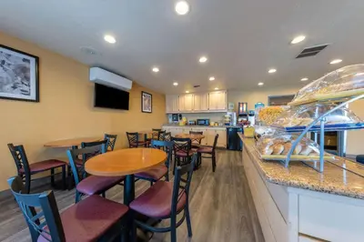 a restaurant with tables and chairs and a counter at Days Inn by Wyndham Lathrop in Lathrop
