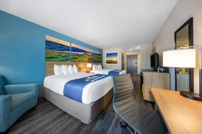 a hotel room with a large bed and a desk at Days Inn by Wyndham Lathrop in Lathrop