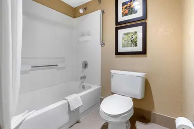 a bathroom with a toilet and a tub and a sink at Comfort Inn Lathrop Stockton Airport in Lathrop