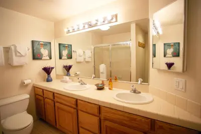 a bathroom with two sinks and a toilet and a mirror at Silver Bear # 20 in Mammoth Lakes