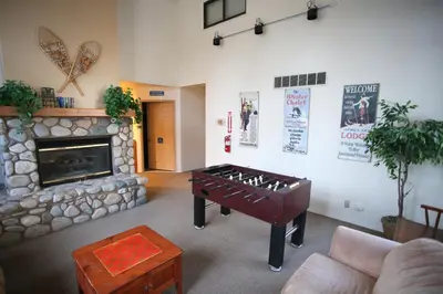 a living room with a table in front of a fireplace at Silver Bear # 36 in Mammoth Lakes